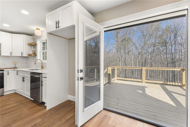 kitchen with open shelves, white cabinetry, stainless steel appliances, and a sink