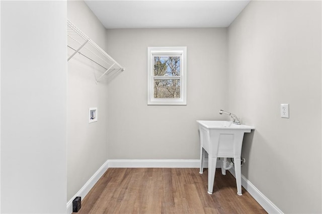 clothes washing area featuring laundry area, hookup for a washing machine, baseboards, and wood finished floors