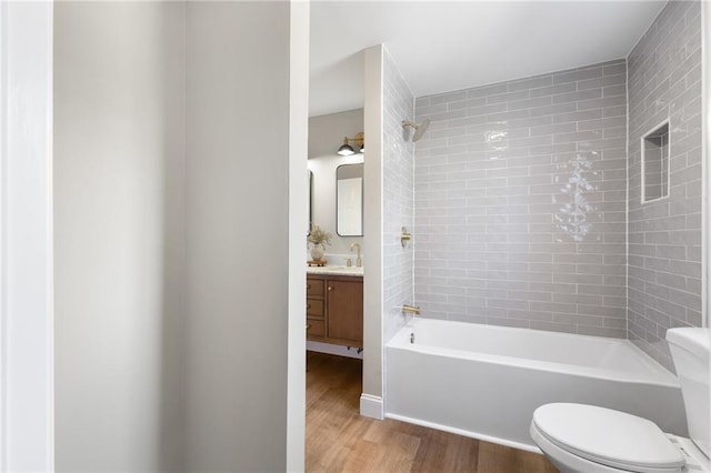 bathroom with vanity, wood finished floors, shower / tub combination, and toilet