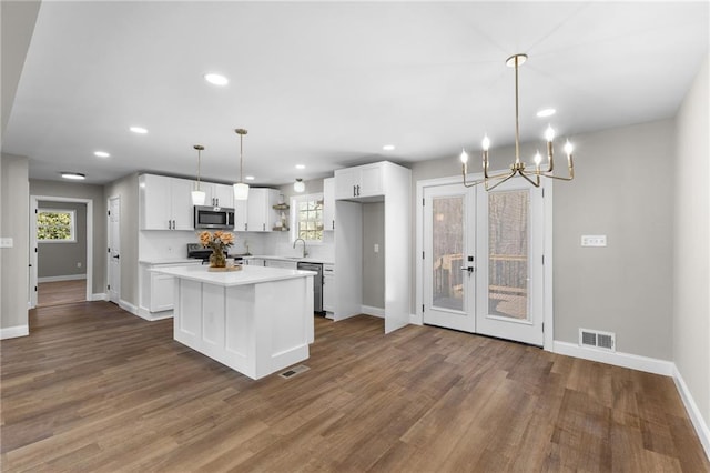 kitchen featuring open shelves, stainless steel appliances, light countertops, visible vents, and white cabinetry