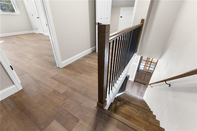 staircase with wood finished floors and baseboards