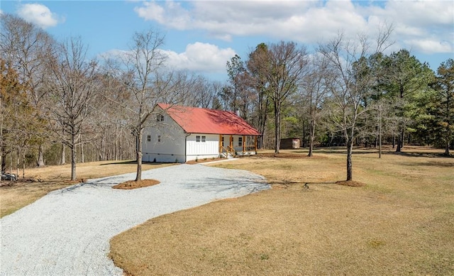 view of front of property featuring gravel driveway and a front yard