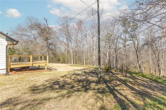 view of yard with a deck and a forest view