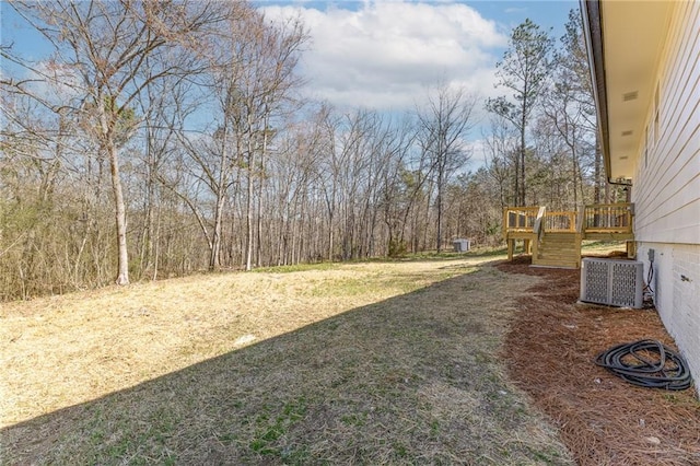 view of yard featuring a deck and central AC