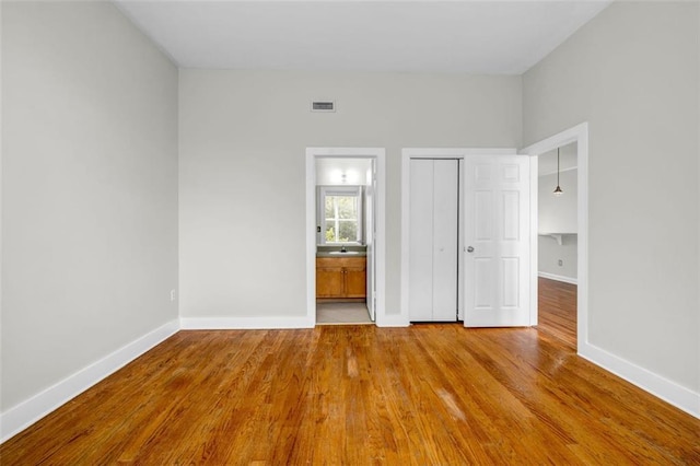 502 SW Pryor St SW Unit 325, Atlanta, GA 30312 - unfurnished bedroom featuring baseboards, wood finished floors, connected bathroom, and a closet