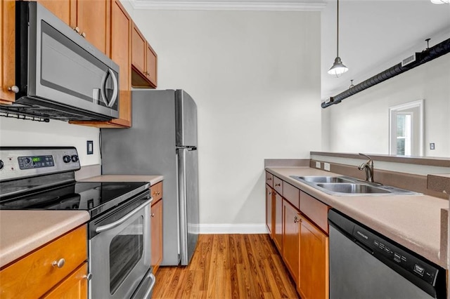 502 SW Pryor St SW Unit 325, Atlanta, GA 30312 - kitchen featuring appliances with stainless steel finishes, brown cabinetry, light wood-style floors, baseboards, and ornamental molding