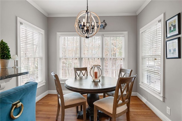 dining area with a chandelier, crown molding, and light hardwood / wood-style floors