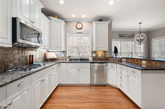 kitchen featuring white cabinets, appliances with stainless steel finishes, light hardwood / wood-style flooring, and sink