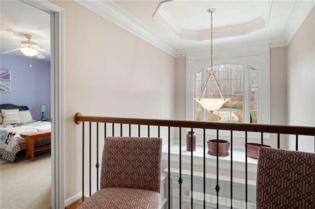 corridor with carpet, a tray ceiling, and crown molding