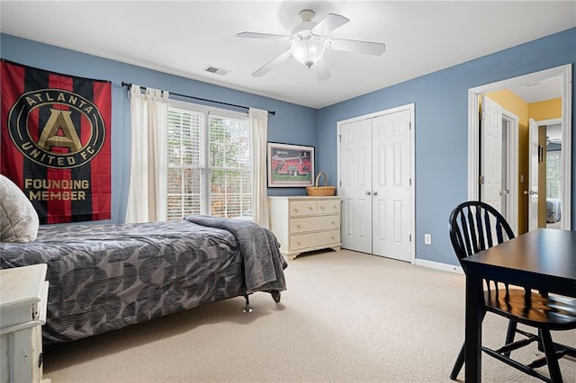 bedroom featuring ceiling fan, a closet, and light colored carpet