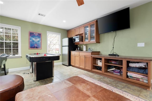 kitchen with a kitchen bar, light tile patterned flooring, a kitchen island, and stainless steel appliances