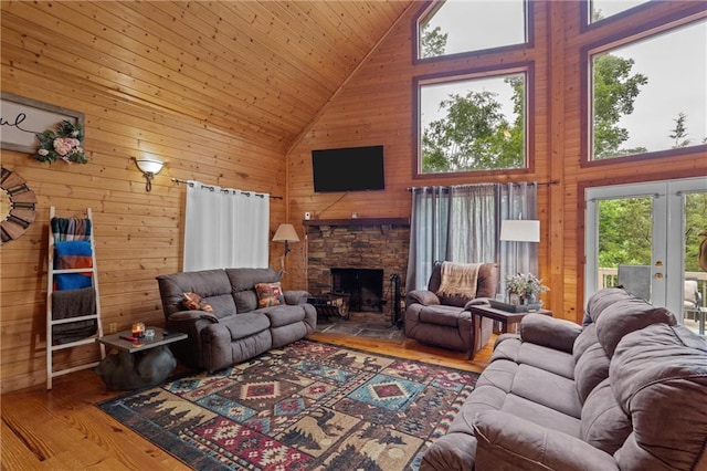 1182 Cedar Rd, Lincolnton, GA 30817 - living room featuring high vaulted ceiling, wooden walls, hardwood / wood-style floors, french doors, and a fireplace