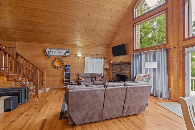 1182 Cedar Rd, Lincolnton, GA 30817 - living area featuring high vaulted ceiling, wooden walls, a fireplace, stairway, and hardwood / wood-style floors