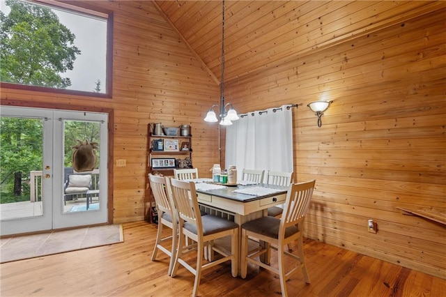 1182 Cedar Rd, Lincolnton, GA 30817 - dining room featuring french doors, a chandelier, wooden walls, light wood finished floors, and high vaulted ceiling