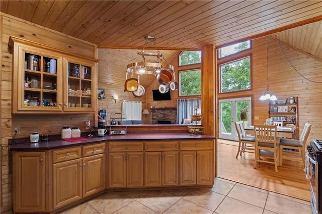 1182 Cedar Rd, Lincolnton, GA 30817 - kitchen with wooden walls, wooden ceiling, dark countertops, light tile patterned floors, and a chandelier
