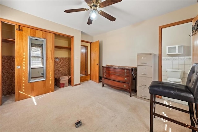 living area with light carpet, tile walls, and ceiling fan