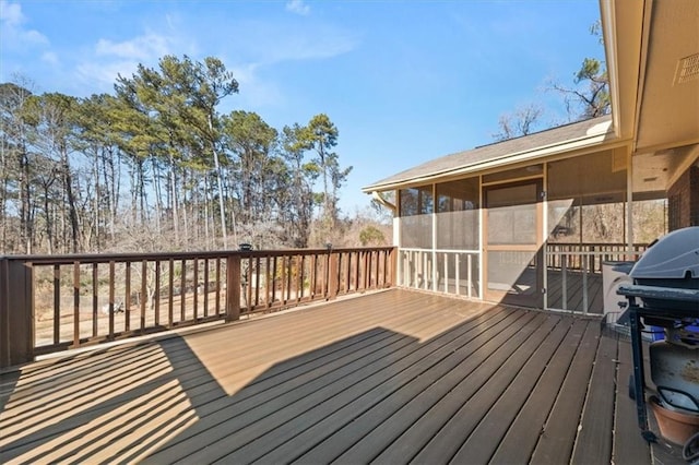 wooden terrace with a grill and a sunroom