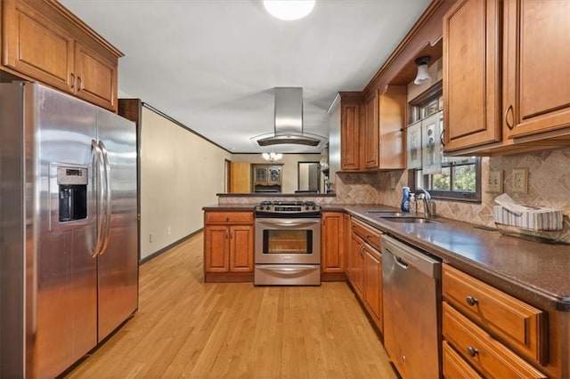 kitchen featuring island range hood, kitchen peninsula, appliances with stainless steel finishes, light hardwood / wood-style flooring, and sink