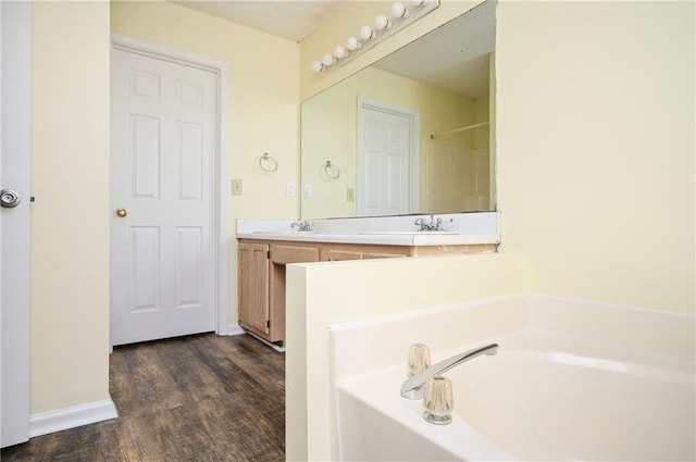 4157 Lake Mist Dr NW, Kennesaw, GA 30144 - bathroom featuring double vanity, wood finished floors, baseboards, a bath, and a sink