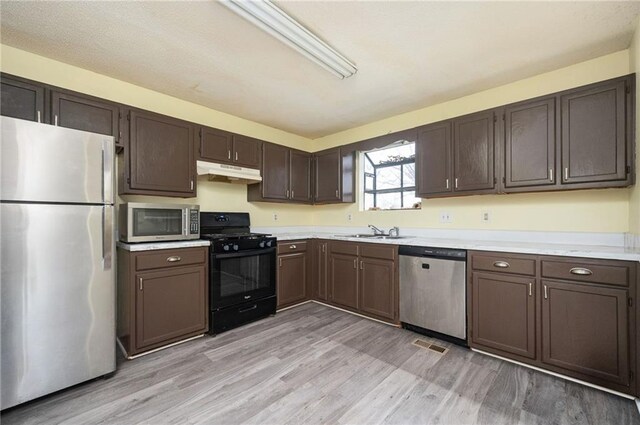 4157 Lake Mist Dr NW, Kennesaw, GA 30144 - kitchen with a sink, appliances with stainless steel finishes, under cabinet range hood, and light wood finished floors
