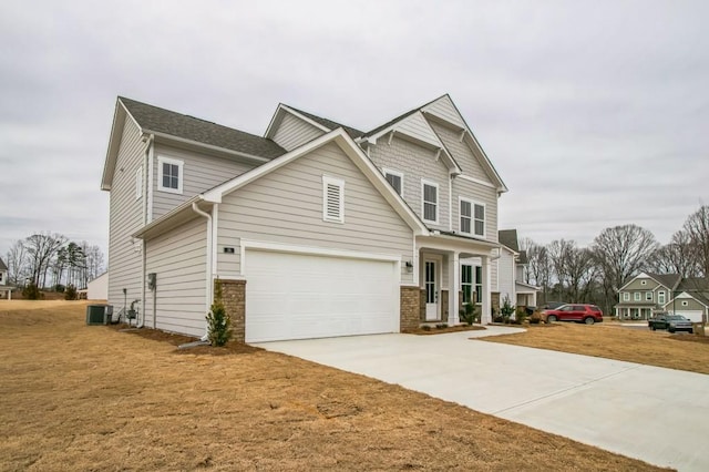 view of front of property with central AC unit, a garage, and a front lawn