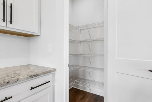 39 Pecan Ct, Hoschton, GA 30548 - kitchen featuring white cabinets, sink, an island with sink, and wall chimney range hood