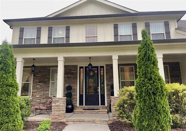 craftsman-style home featuring board and batten siding, stone siding, and covered porch