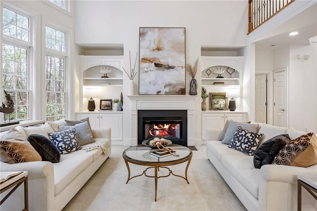 living room featuring a towering ceiling and built in features