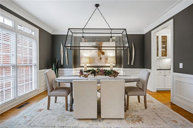 dining area featuring ornamental molding and wood-type flooring