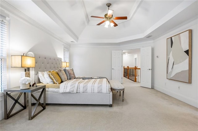 bedroom featuring crown molding, ceiling fan, a tray ceiling, and light carpet