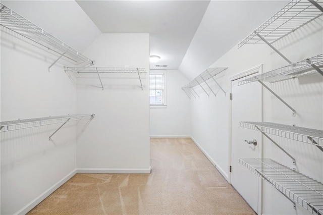 spacious closet featuring light carpet and vaulted ceiling