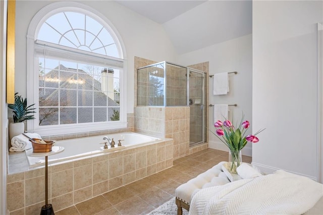 bathroom with tile patterned flooring, vaulted ceiling, and separate shower and tub