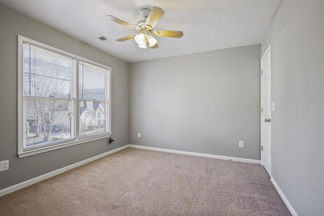 unfurnished room with visible vents, baseboards, a ceiling fan, and carpet flooring