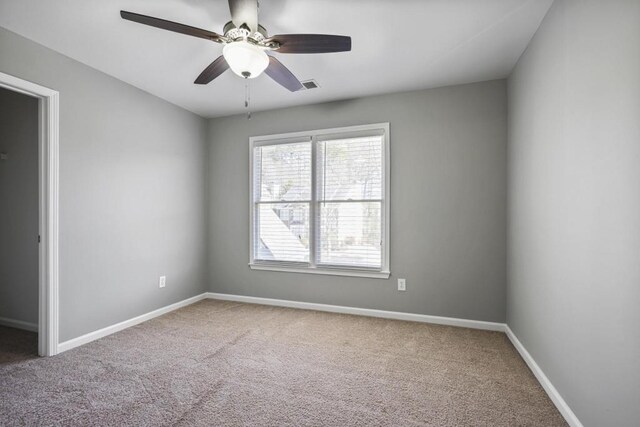 unfurnished room with visible vents, baseboards, a ceiling fan, and carpet flooring