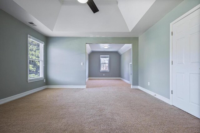 spare room featuring visible vents, baseboards, lofted ceiling, carpet floors, and a ceiling fan