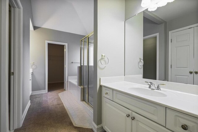 bathroom with a spacious closet, baseboards, lofted ceiling, a stall shower, and vanity