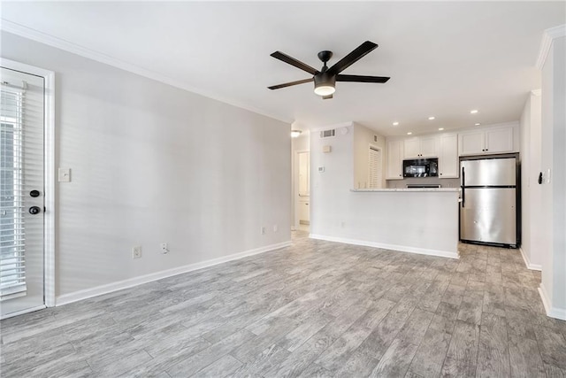 unfurnished living room with crown molding, ceiling fan, light wood-style flooring, and baseboards