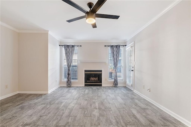 unfurnished living room featuring baseboards, light wood-type flooring, a fireplace, and a healthy amount of sunlight