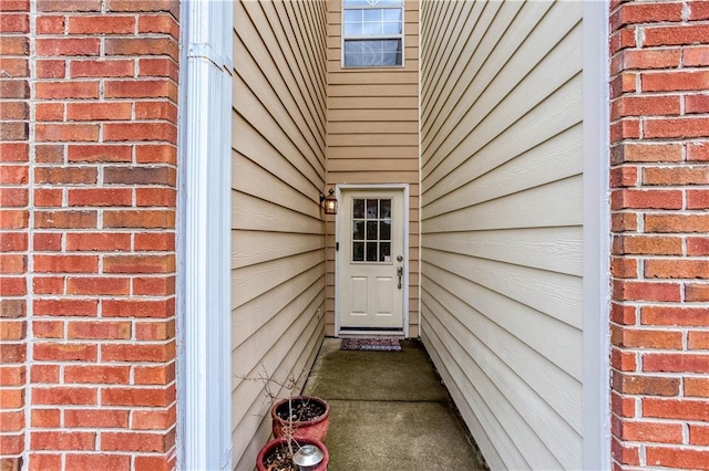 entrance to property featuring brick siding