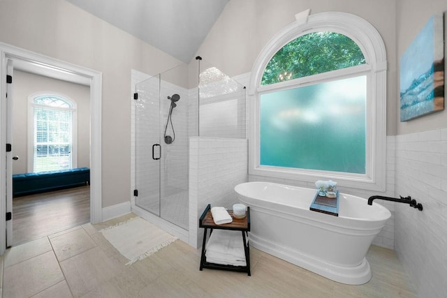 7251 Bluewater Ln, Douglasville, GA 30135 - bathroom with a shower stall, a freestanding bath, and tile walls