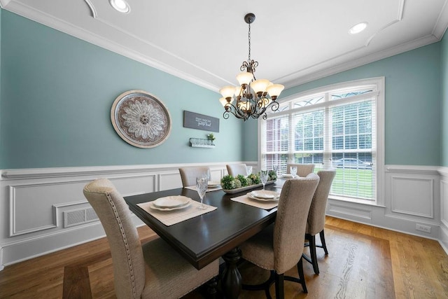7251 Bluewater Ln, Douglasville, GA 30135 - dining room with ornamental molding, a chandelier, a wainscoted wall, a decorative wall, and wood finished floors