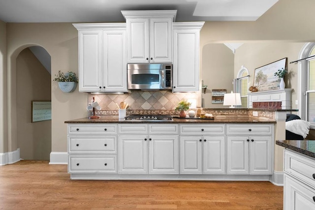 7251 Bluewater Ln, Douglasville, GA 30135 - kitchen with appliances with stainless steel finishes, dark stone countertops, white cabinets, and tasteful backsplash