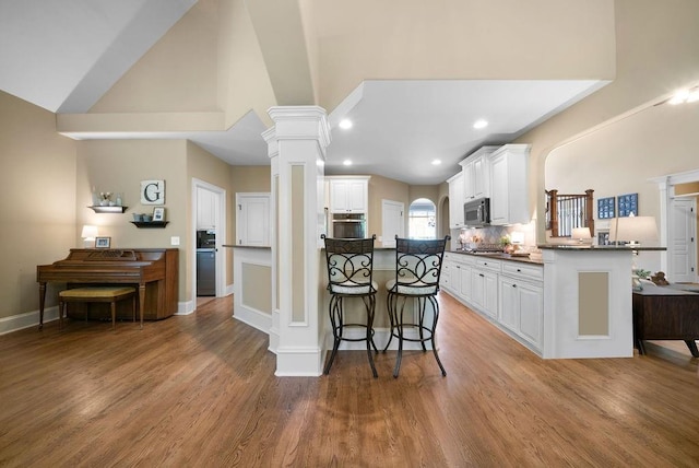 7251 Bluewater Ln, Douglasville, GA 30135 - kitchen featuring dark countertops, stainless steel appliances, a kitchen breakfast bar, a peninsula, and white cabinets