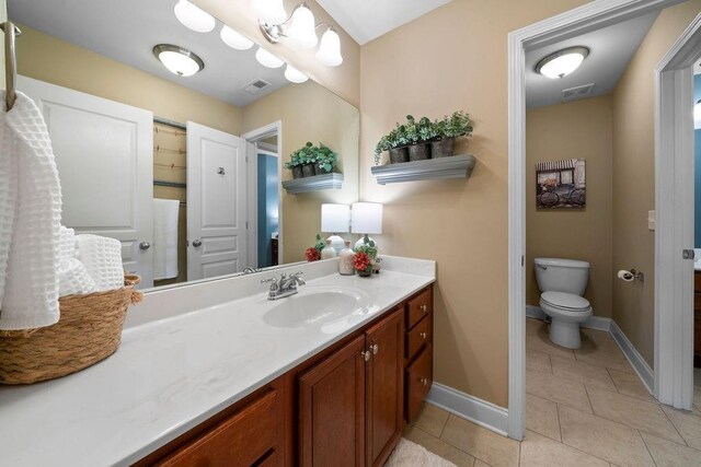 7251 Bluewater Ln, Douglasville, GA 30135 - bathroom with vanity, toilet, baseboards, and tile patterned floors