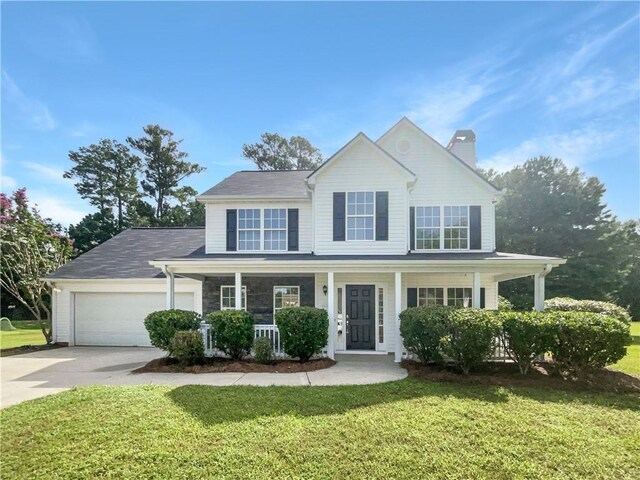 view of front of house featuring covered porch, a garage, and a front yard