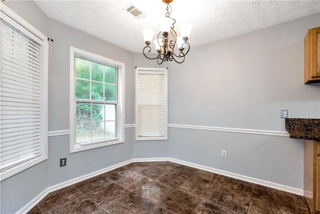 285 Kentshire Pl, Lawrenceville, GA 30044 - unfurnished dining area with a chandelier, baseboards, and a textured ceiling