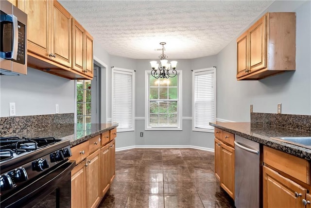 285 Kentshire Pl, Lawrenceville, GA 30044 - kitchen with appliances with stainless steel finishes, a chandelier, baseboards, dark tile patterned flooring, and decorative light fixtures