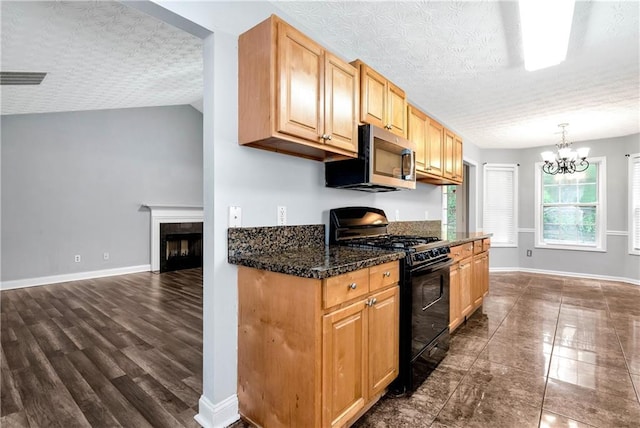 285 Kentshire Pl, Lawrenceville, GA 30044 - kitchen featuring black range with gas cooktop, stainless steel microwave, a chandelier, baseboards, and a fireplace