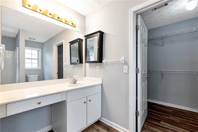 285 Kentshire Pl, Lawrenceville, GA 30044 - bathroom with wood finished floors, vanity, a walk in closet, baseboards, and toilet