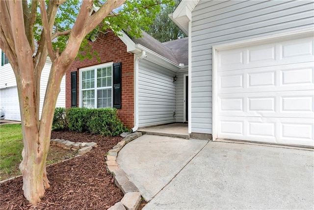 285 Kentshire Pl, Lawrenceville, GA 30044 - property entrance featuring brick siding, concrete driveway, an attached garage, and a shingled roof
